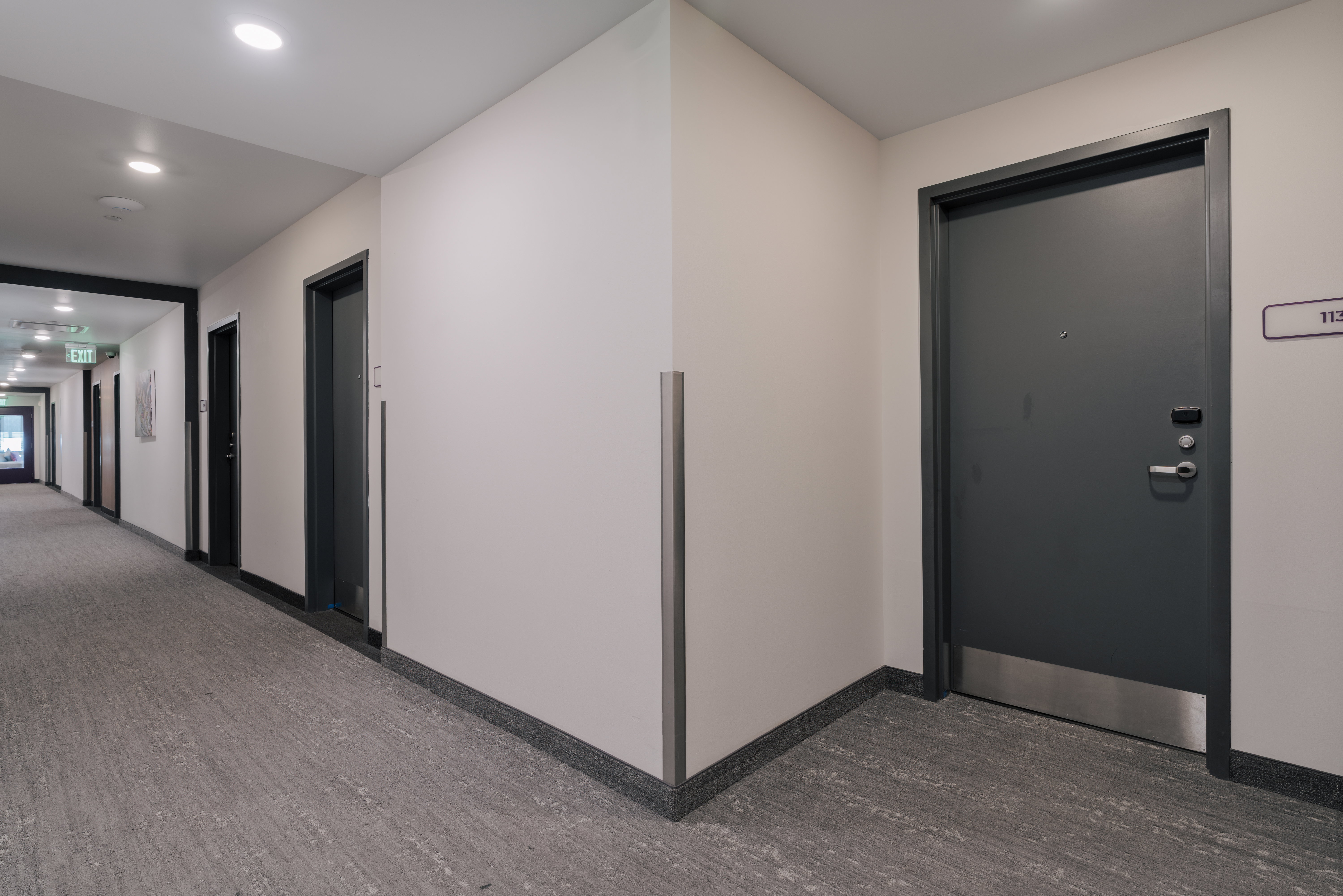Corridor with dark wood-style flooring, baseboards, and recessed lighting