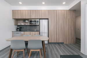 Dining space featuring dark wood-style flooring, baseboards, and recessed lighting