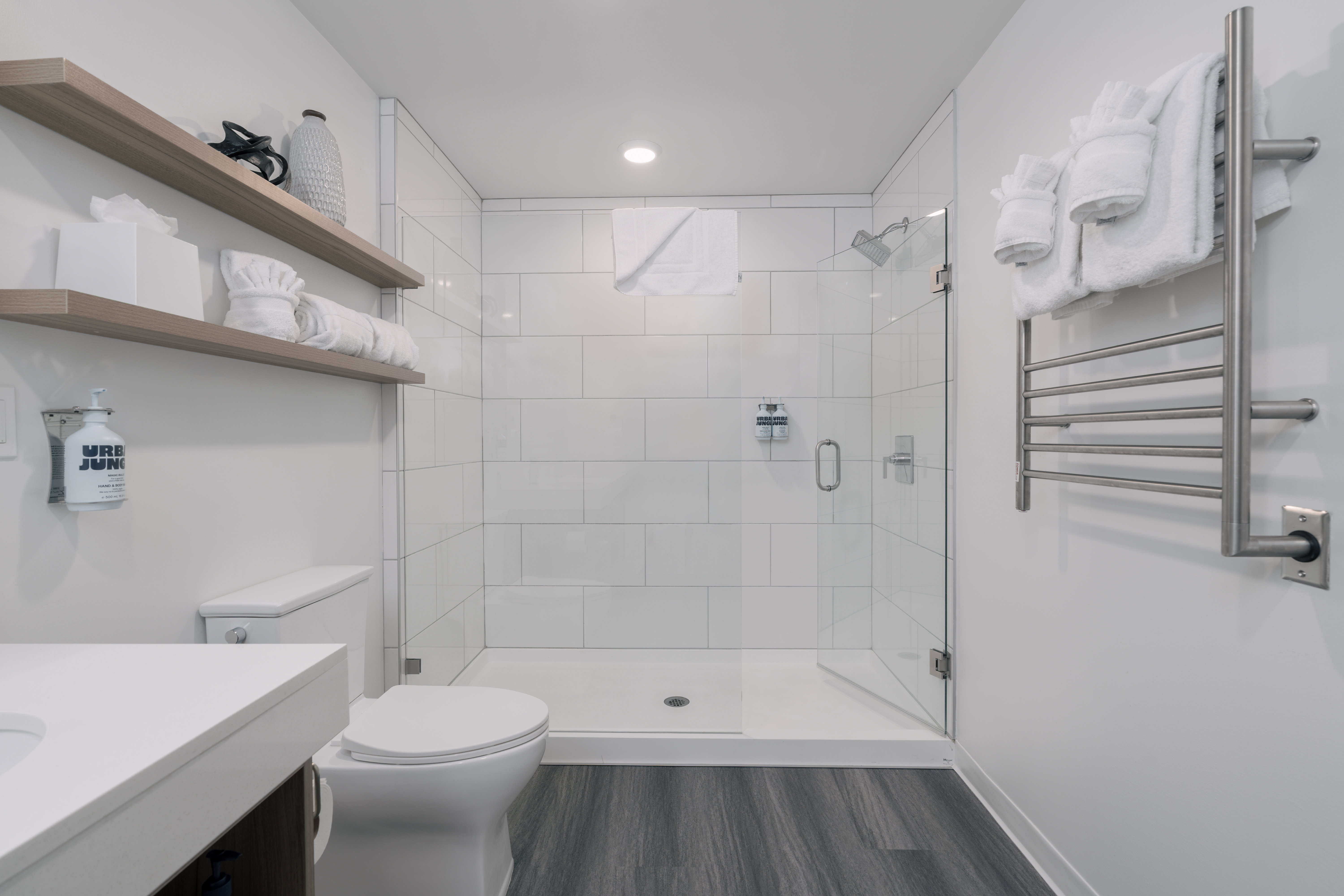Bathroom with radiator, toilet, a stall shower, wood finished floors, and vanity