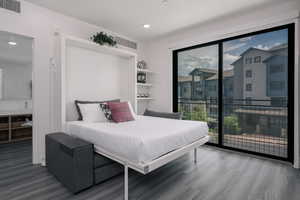 Bedroom featuring wood finished floors, access to exterior, multiple windows, and recessed lighting