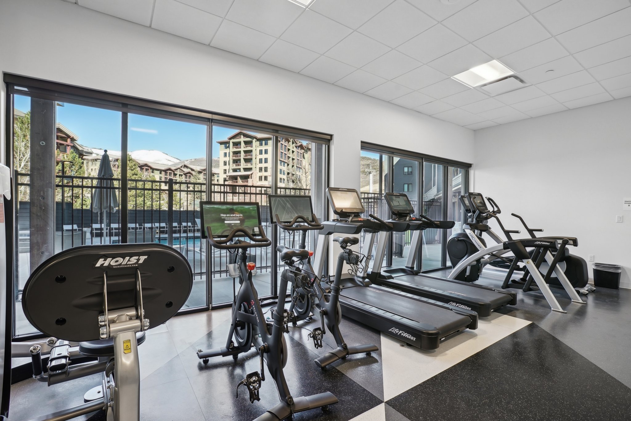 Workout area featuring healthy amount of natural light and a drop ceiling