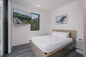 Bedroom with wood finished floors, baseboards, and recessed lighting