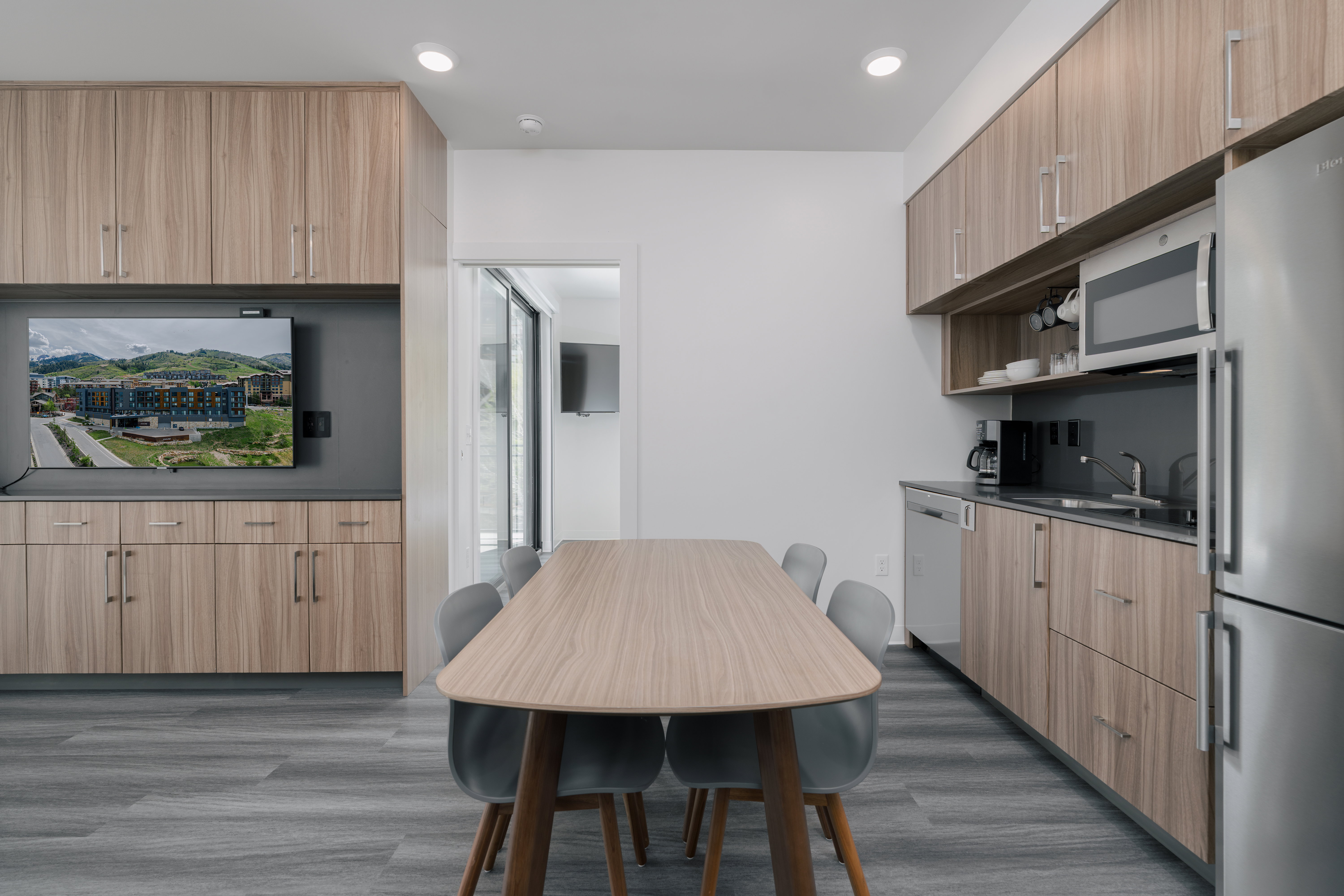 Kitchen featuring appliances with stainless steel finishes, a sink, dark wood-style floors, dark countertops, and light brown cabinets
