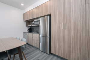 Kitchen featuring appliances with stainless steel finishes, wood finished floors, a sink, modern cabinets, and open shelves