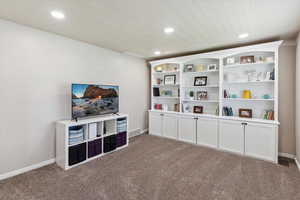 Living area with carpet, recessed lighting, and baseboards