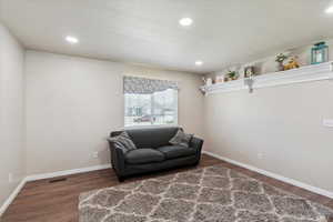 Living area featuring wood finished floors, baseboards, and recessed lighting