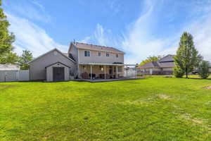 Rear view of house with a patio area and a gate
