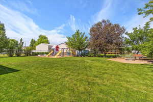 View of green lawn featuring a playground