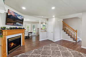 Entrance foyer featuring wood finished floors, stairs, recessed lighting, baseboards, and a fireplace