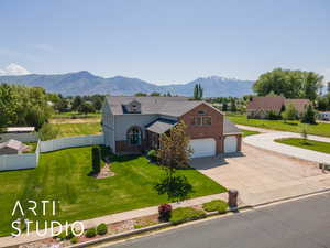 View of front of house with concrete driveway, a mountain view, a garage, and roof with shingles