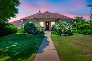 View of front of property featuring a front lawn, a chimney, and a porch