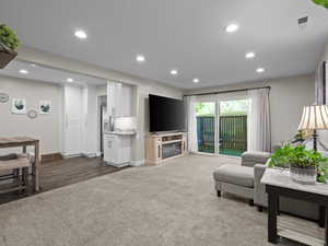 Living area featuring recessed lighting, baseboards, carpet, and wood finished floors