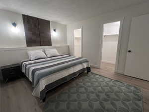 Bedroom with wood finished floors and a textured ceiling