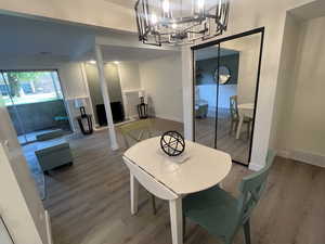 Dining space with wood finished floors and a chandelier