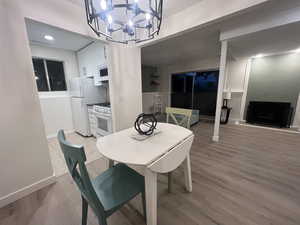Dining room with a chandelier, light wood-style floors, and a fireplace