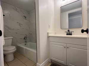Full bath featuring vanity, shower / tub combination, and tile patterned flooring