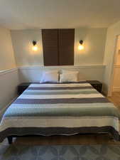 Bedroom with a textured ceiling and wood finished floors