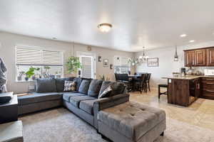 Living area featuring a chandelier, light tile patterned floors, and recessed lighting