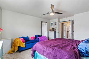 Carpeted bedroom with a ceiling fan