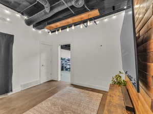 Below grade area featuring rail lighting and baseboards