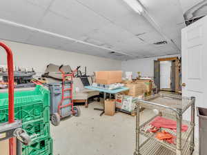 Below grade area with a drop ceiling and tile patterned floors