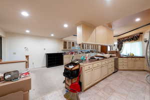 Kitchen featuring recessed lighting, dishwasher, glass insert cabinets, light brown cabinetry, and light carpet