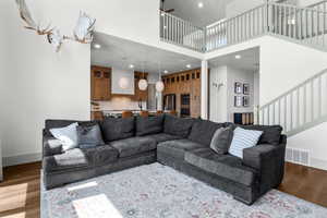 Living room with stairway, a high ceiling, recessed lighting, and baseboards