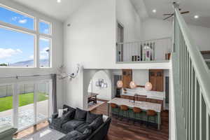 Living room featuring high vaulted ceiling, arched walkways, a ceiling fan, and recessed lighting