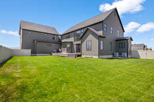 Back of property with a sunroom, central air condition unit, and a fully fenced yard with gate to rear property.