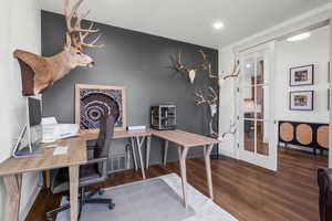 Man floor office space featuring accent wall and french style glass doors.