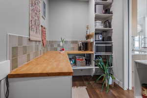 Butler's pantry featuring butcher block counters, tile backsplash, "Costco door" with access to the garage. Plumbed for water fountain.