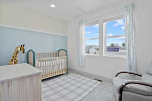 Bedroom with a nursery area, baseboards, carpet floors, and recessed lighting