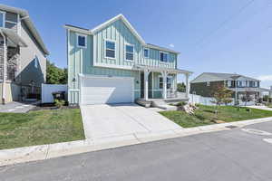 View of front of house with board and batten siding, a porch, a garage, and concrete driveway