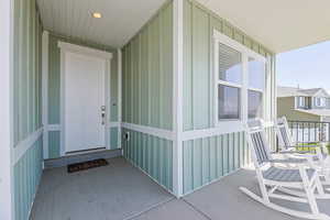 Entrance to property featuring board and batten siding and covered porch