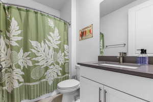 Full bath with vanity, toilet, and a shower with curtain