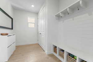 Mudroom featuring light wood finished floors, baseboards, and recessed lighting