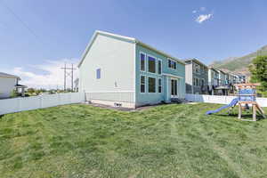 Rear view of house with a playground, entry steps, a mountain view, and a residential view