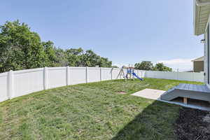 View of yard with a playground and a patio