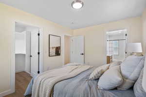 Primary suite Bedroom with wood finished floors and ensuite bath