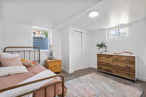 Bedroom featuring carpet, a closet, multiple windows, and a textured ceiling