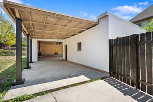 one of the garage entrances - View of patio / terrace with an attached carport
