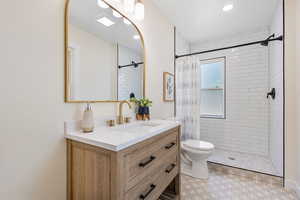 Bathroom featuring vanity, a tile shower, and recessed lighting