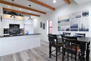 Dining area featuring recessed lighting, light wood-style flooring, baseboards, and wood ceiling with exposed beams