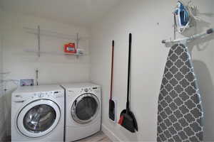 Washroom featuring light wood-style floors and washing machine and dryer