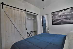 Bedroom with a barn door and a closet