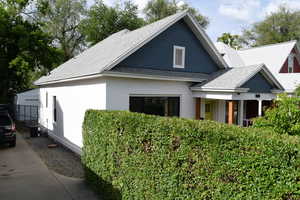 View of front of home with a shingled roof and cooling unit