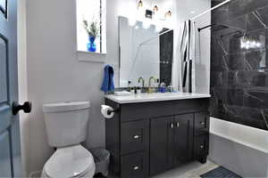 Full bathroom with vanity, toilet, and shower / bath combo with shower curtain