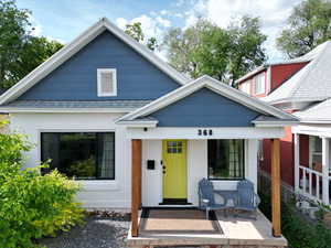 View of front of property featuring covered porch and a shingled roof