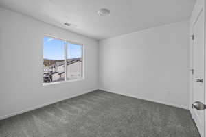 Carpeted spare room with baseboards and a textured ceiling