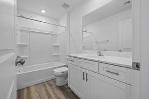 Full bathroom featuring vanity, toilet, shower / washtub combination, and wood finished floors
